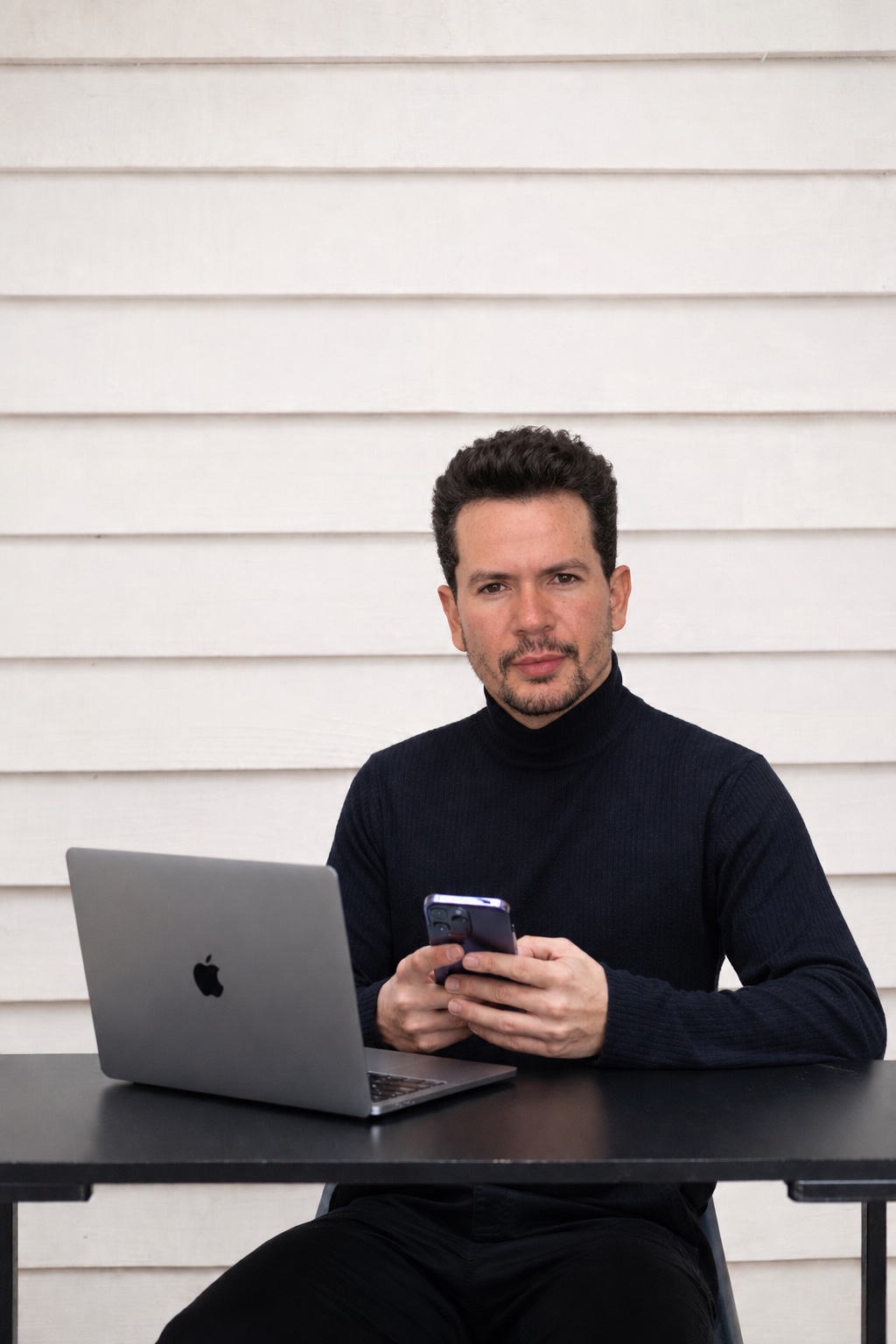 Cássio Macedo sentado à mesa com notebook